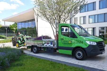 Professionelle Rasenpflege in Göttingen: Ein Mitarbeiter von Bandelow & Uhlendorff fährt einen Aufsitzmäher für den Einsatz vom Firmen-LKW.