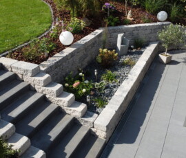 Professionelle Gartengestaltung in Göttingen: Moderner Treppenbau, helle Stützmauern und Terrassenpflasterung fachgerecht umgesetzt von Bandelow & Uhlendorff.